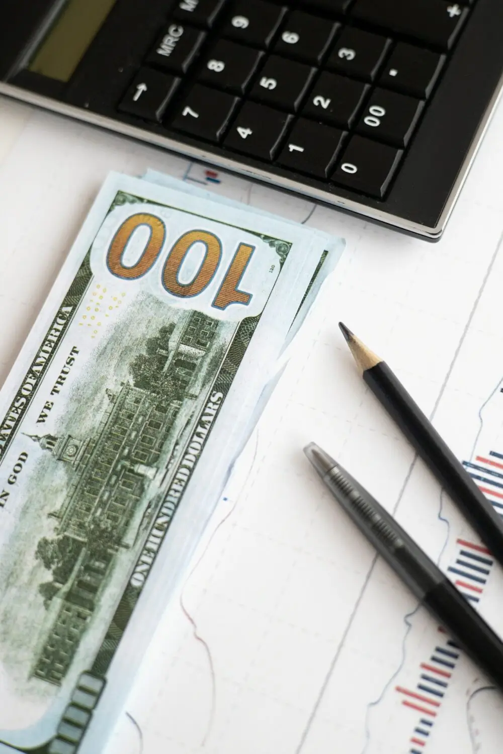 Afbeelding van een calculator en een dollarbiljet, passend bij een artikel dat uitleg geeft over wat verplicht op een loonstrook vermeld moet worden, zoals brutoloon, nettoloon, belastingen, pensioenbijdragen en jaaropgaven.