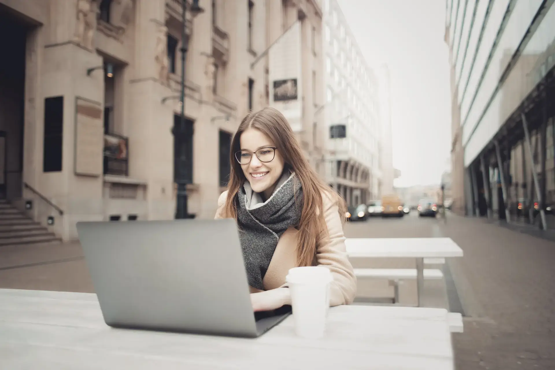 Vrouw die buiten aan haar laptop werkt, illustreert een medewerker die in dienst is op payrollbasis.
