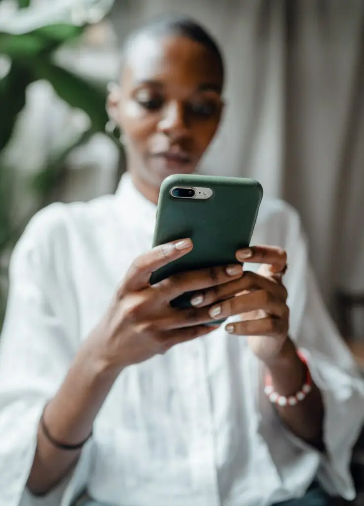 Vrouw bekijkt informatie op haar telefoon, representatief voor het vergelijken van payrolltarieven en het maken van een weloverwogen keuze.