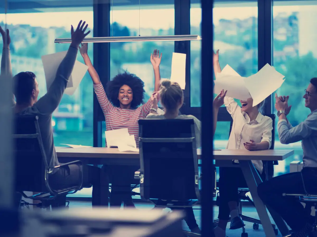 Afbeelding van een enthousiaste groep mensen in een kantooromgeving, illustrerend de WKR-verhoging naar 3 procent in 2023.