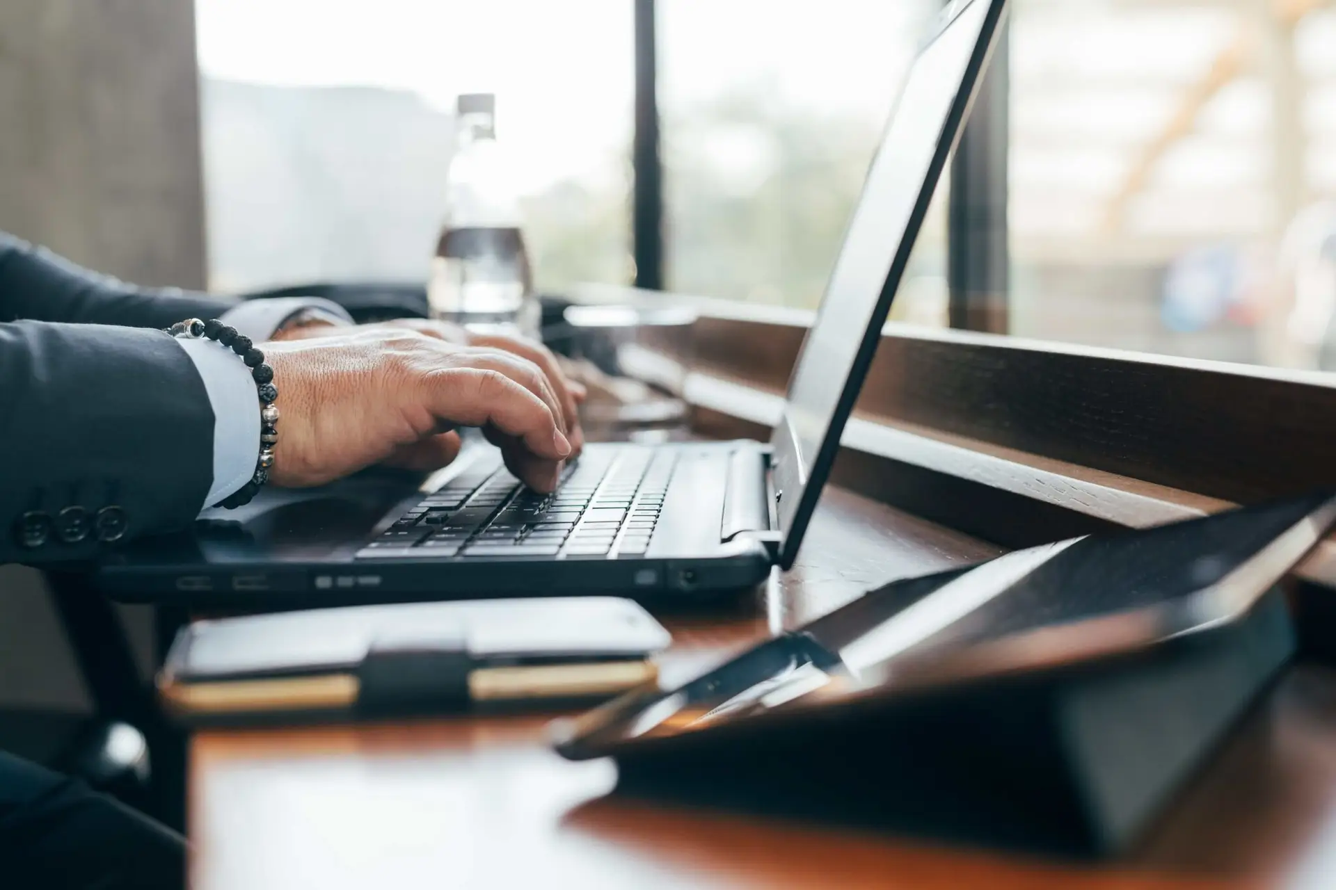 Man die op een laptop werkt, representatief voor de administratieve taken van een payrollbedrijf en de voordelen voor werkgevers.