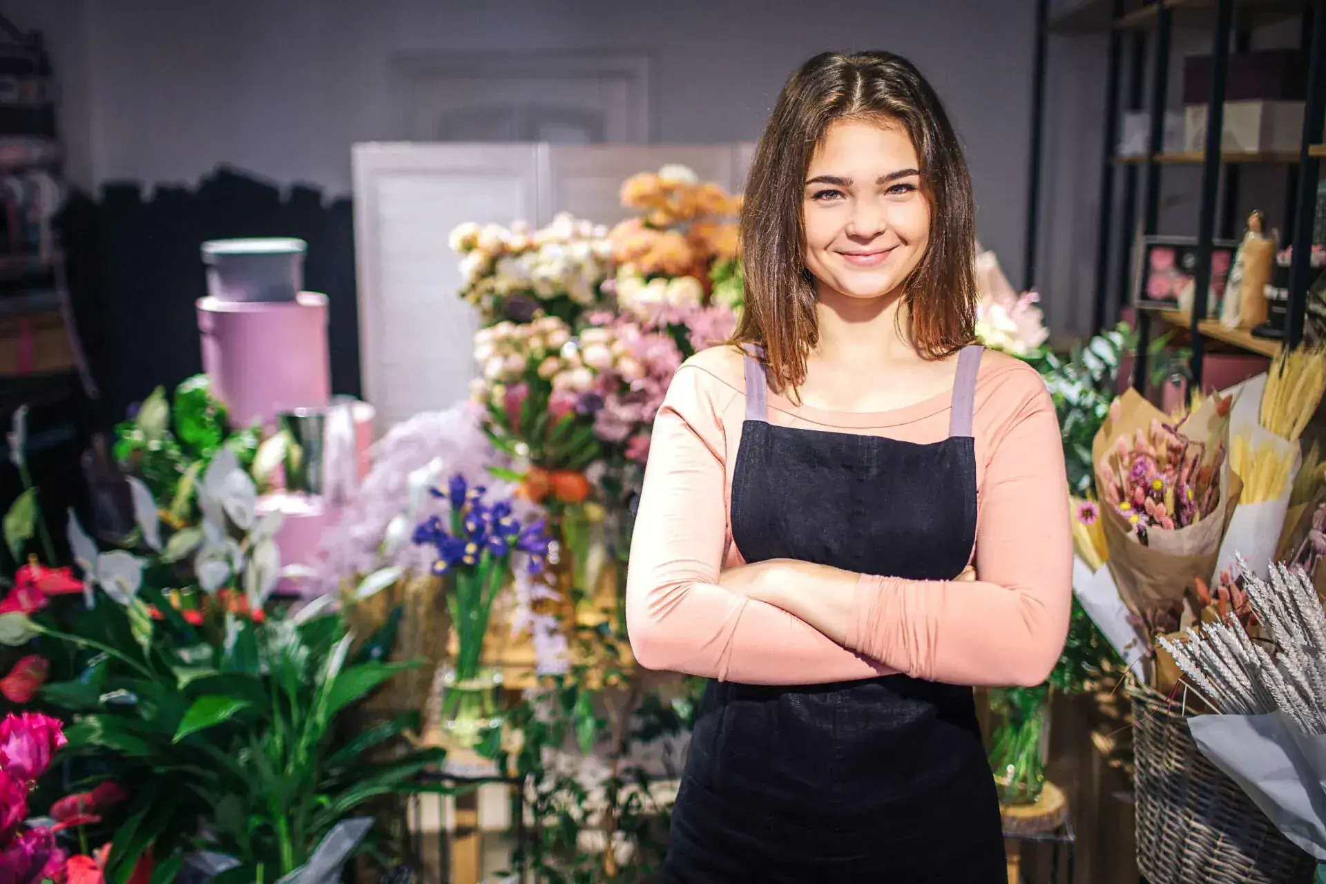 Jonge vrouw in een bloemenwinkel die personeelsbeheer en salarisadministratie symboliseert, met een focus op maatwerk en betrouwbaarheid voor ondernemers.