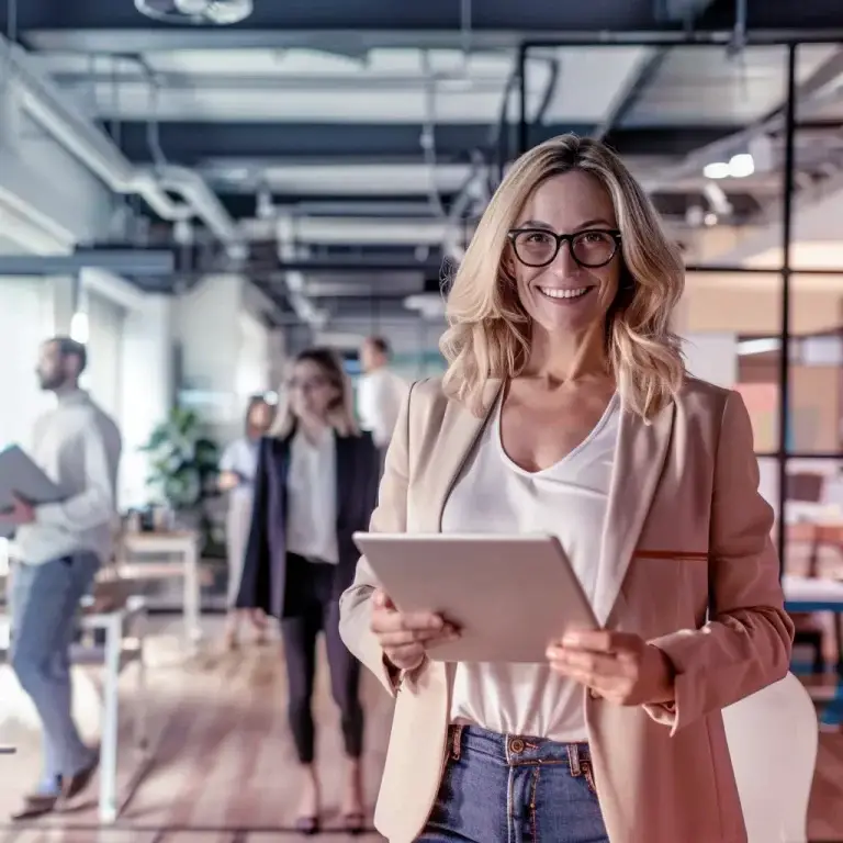 Zakelijke vrouw in een dynamische kantooromgeving, die uitzenden en verlonen vertegenwoordigt als flexibele HR-oplossing voor ondernemers.